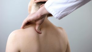 Osteopath assessing a patient's upper neck and base of skull at Tim Wood Healthcare clinic in Maidstone