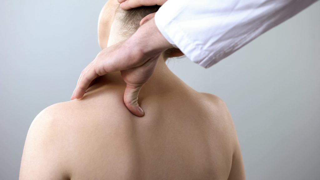 Osteopath assessing a patient's upper neck and base of skull at Tim Wood Healthcare clinic in Maidstone