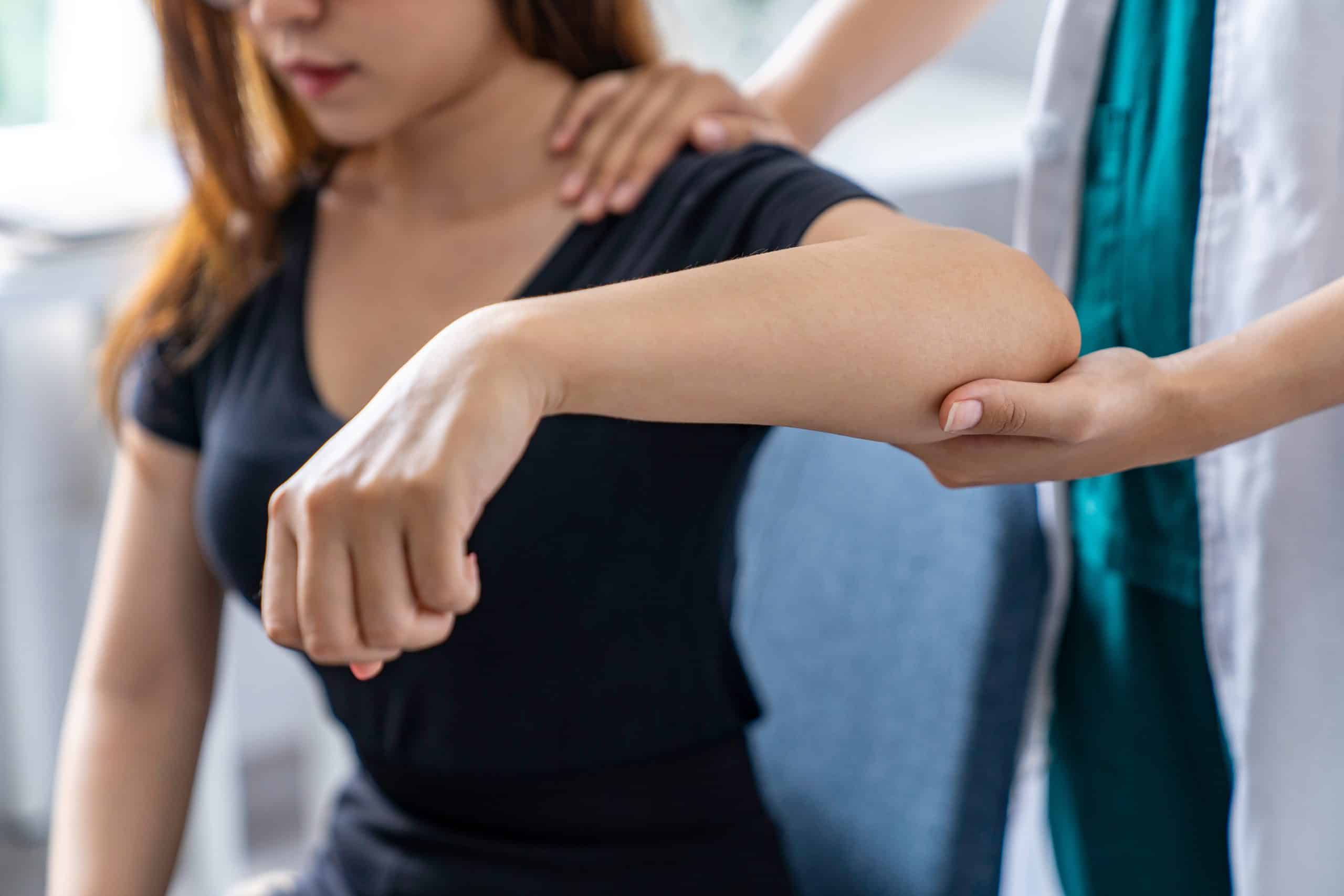 Osteopath assessing a patient's tennis elbow on the outer forearm at Tim Wood Healthcare clinic in Rainham